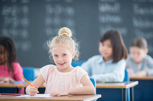 istock Little Girl Writing at Her Desk 526154816