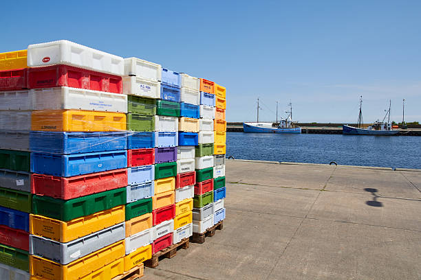 Nexoe, Denmark - July 13, 2013: colourful fish crates of plastic, standing stacked on the harbor of Nexoe, Bornholm