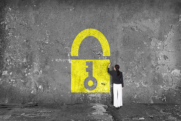 businesswoman drawing padlock on the wall