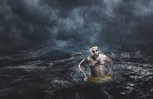 Man in the sea while storming Man in the sea with lifebuoy while storming storming stock pictures, royalty-free photos & images