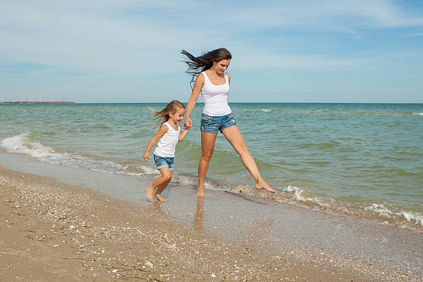 Madre e sua figlia che si diverte in spiaggia - foto stock