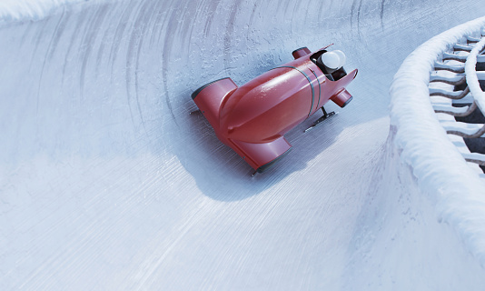 Bobsleigh team is riding on a high speed in a turn