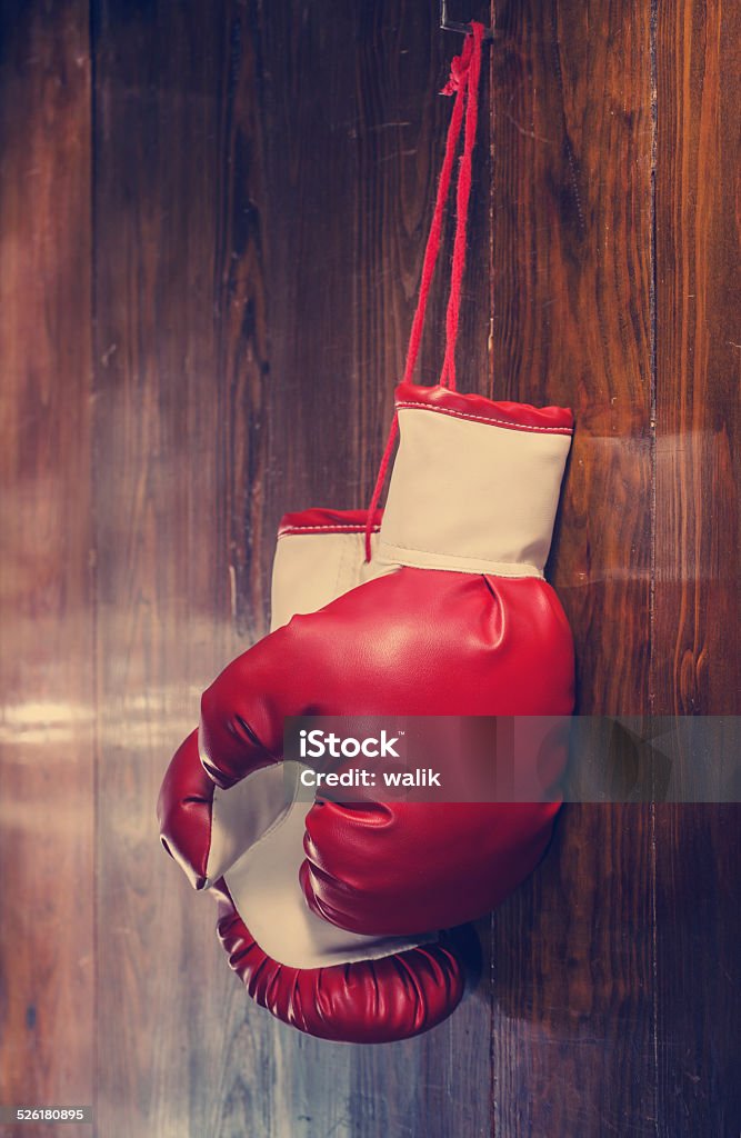 Old boxing gloves hanging on the wall Boxing gloves hanging on wooden wall. Boxing Glove Stock Photo