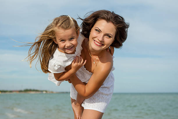 istock Mother and her daughter  having fun on the beach 526180961
