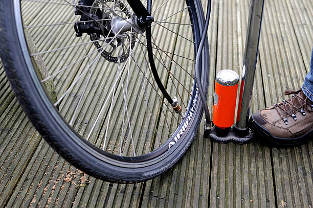 Vinkeveen, The Netherlands - November 25, 2014: The tire of the front wheel  of a bicycle is being inflated with a floor pump with pressure gauge.