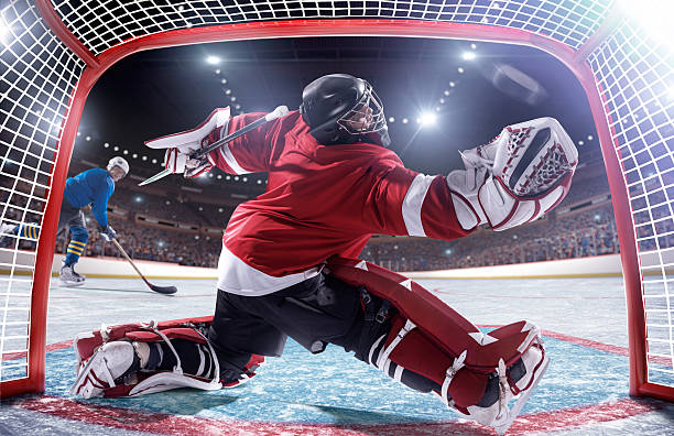 joueur de hockey sur glace de marquer - ice hockey hockey puck playing shooting at goal photos et images de collection