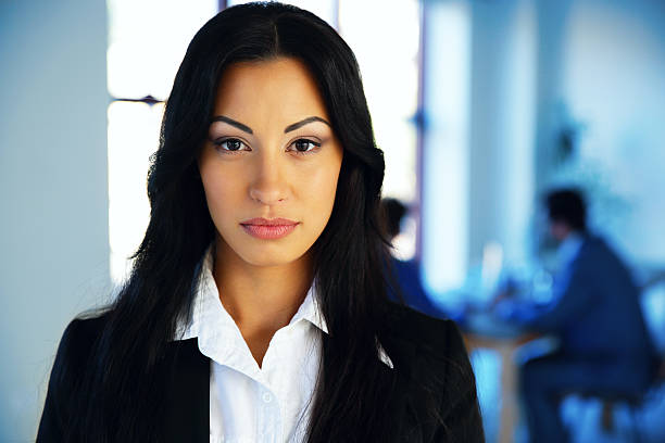 istock woman standing in office with colleagues 526199631