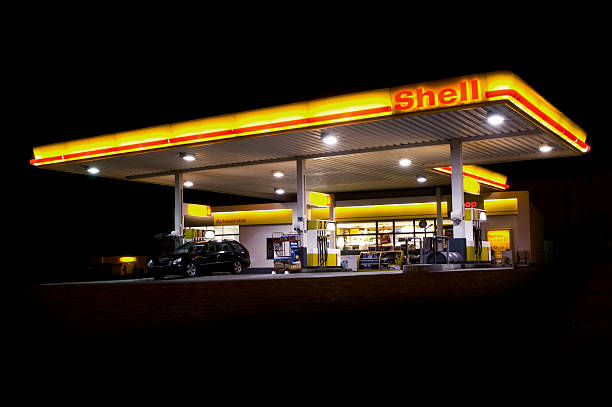 la station essence shell à minuit - gas station service red yellow photos et images de collection