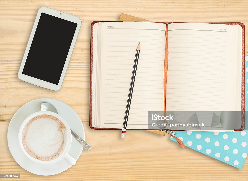 notebook with pencil, smart phone and coffee cup notebook with pencil, smart phone and coffee cup on wooden background. Backgrounds Stock Photo