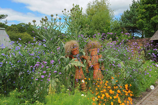 Terracotta Scarecrowin the Garden at Rosemoor, Devon, England, UK Terracotta Scarecrow made from Flowerpots in the Fruit and Vegetable Garden at Rosemoor, near Bideford, in the County of Devon, England, UK artichoke vegetable garden gardening english culture stock pictures, royalty-free photos & images