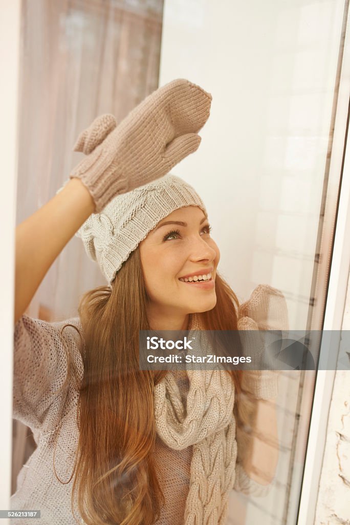 The best style in winter is warmth Shot of a beautiful young woman looking out the window in winter fashion 20-29 Years Stock Photo