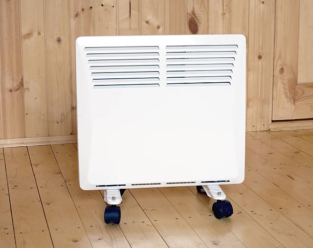 istock White electric convector heater in wooden house 526213367