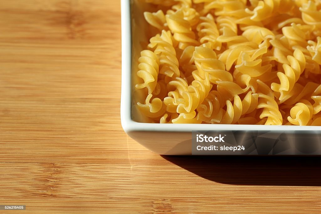 Uncooked Italian pasta noodles background on wooden texture Abstract Stock Photo