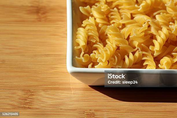 Uncooked Italian Pasta Noodles Background On Wooden Texture Stock Photo - Download Image Now