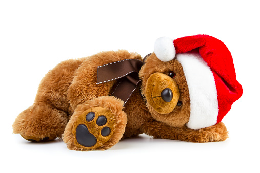 Toy teddy bear wearing a santa hat isolated on white background