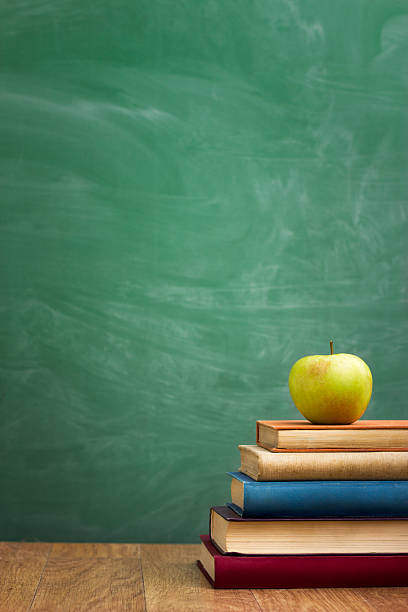 школа книг и apple на стол - green board стоковые фото и изображения
