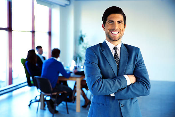 istock Cheerful businessman standing with arms folded 526223335