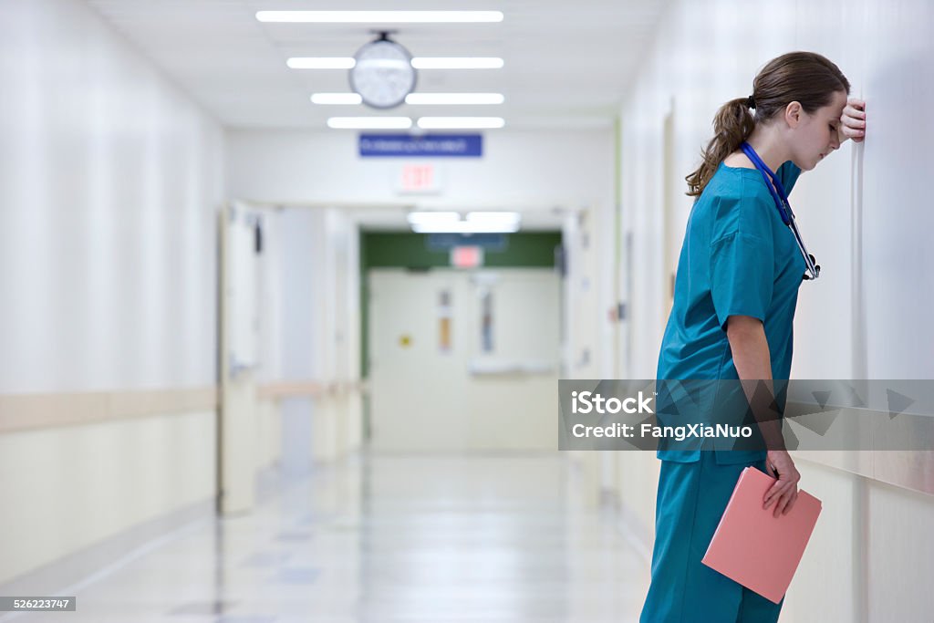 Doctor Resting Head on Wall Doctor Stock Photo