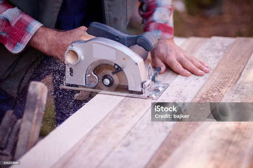 Man cutting wood with circular saw Chopping Food Stock Photo