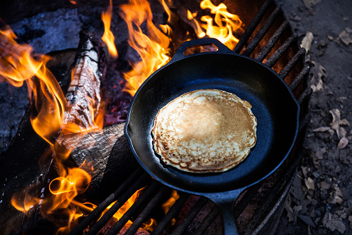 cooking a pancake over a campfire