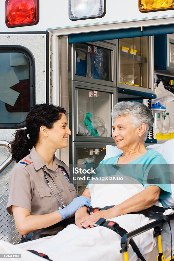 Paramedic with senior patient outside ambulance Ambulance Stock Photo