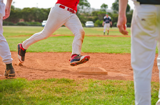 Baseball, sport and person fielder jump on an outdoor sports field during sport game or match. Fitness, training motivation and cardio workout of an athlete man with focus ready to catch a fast ball