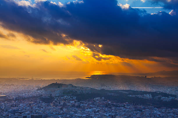 Parthenon temple and Acropolis of Athens - night panorama of Athens city with dramatic sun and clouds 
