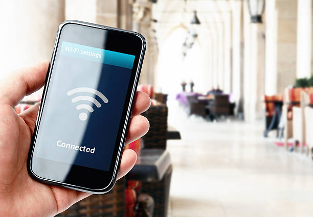istock Hand holding smartphone with wi-fi connection in cafe 526244601