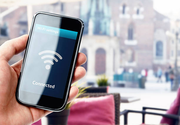 istock Hand holding smartphone with wi-fi connection in cafe 526244615