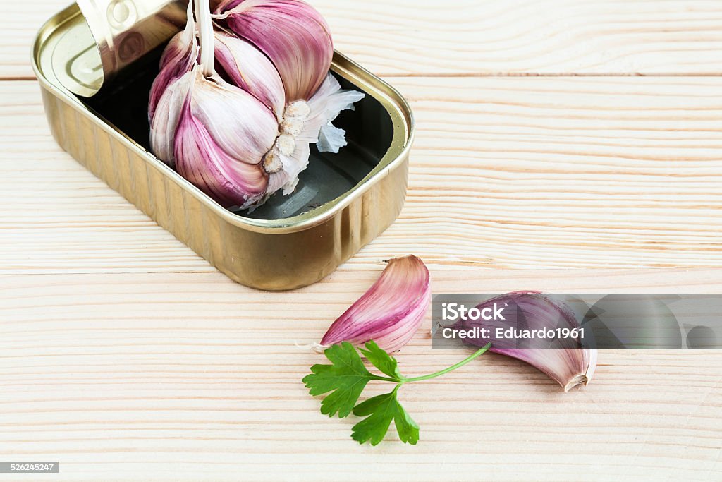 Garlic and parsley in tin can with carrots Garlic in tin can with carrots on wooden board Can Stock Photo