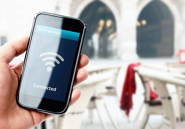 istock Hand holding smartphone with wi-fi connection in cafe 526245463
