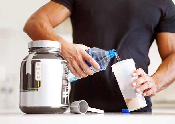 Getting enough protein in your diet? Cropped image of a bodybuilder making himself a protein shake protein stock pictures, royalty-free photos & images