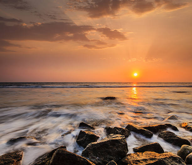 istock Waves and rocks on beach of sunset 526246085