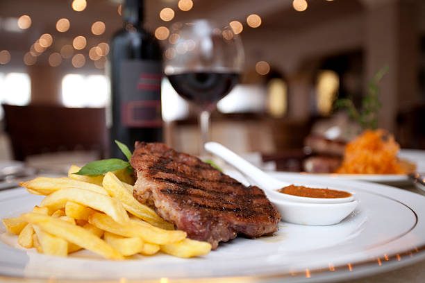 Meat, wine, restaurant A plate with meat and French fries and wine in restaurant convenience food photos stock pictures, royalty-free photos & images