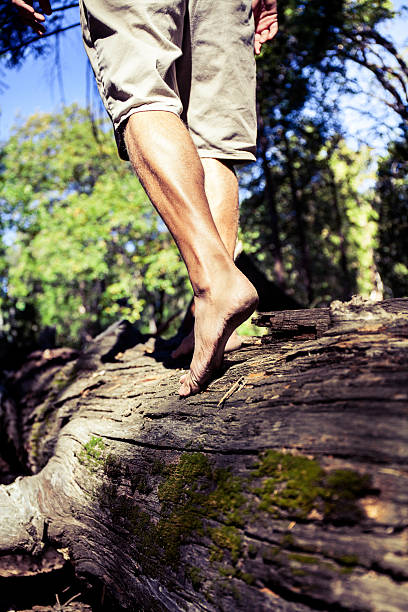 Man walking on log barefoot stock photo