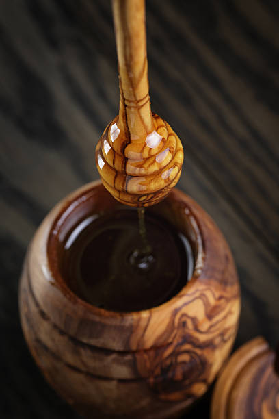 istock maple honey flowing from dipper to pot 526247179