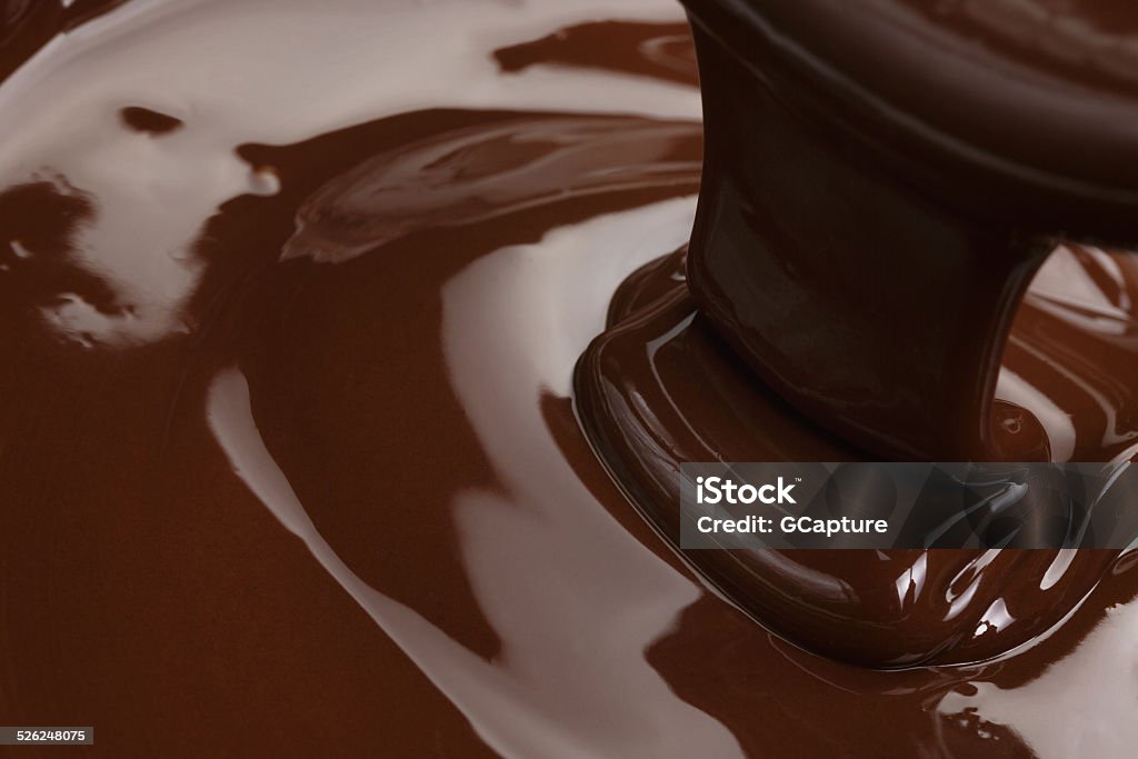 melted dark chocolate flow melted dark chocolate flow, candy or chocolate preparation background Backgrounds Stock Photo