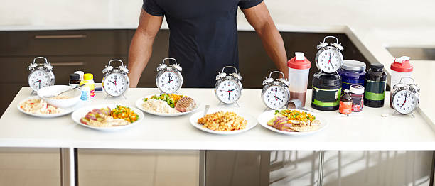 Balanced meals with structured mealtimes is a must Cropped view of a man standing behind his perfectly structured daily food intake food with clock