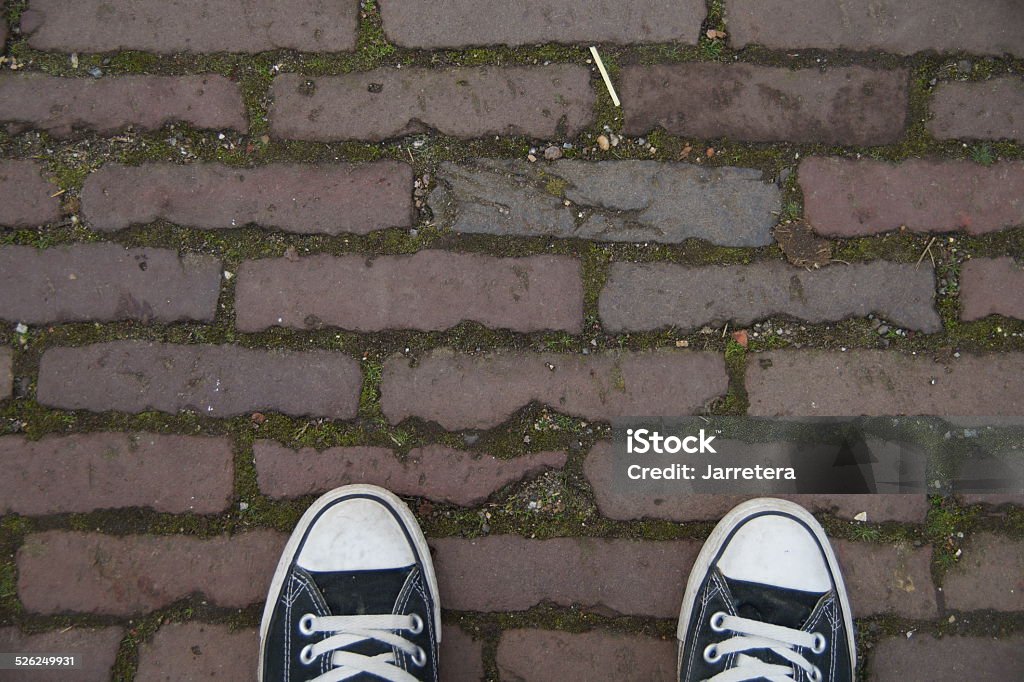 Black canvas sneakers brick street Black canvas baseball shoes on a bricked street Baseball Shoe Stock Photo