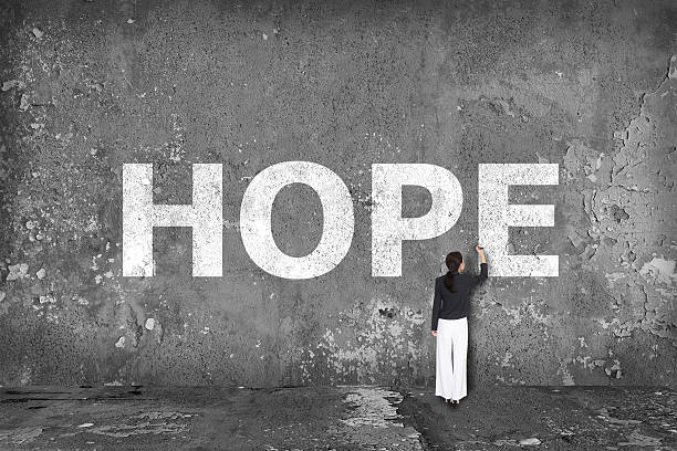 istock businesswoman drawing hope on the wall 526250647