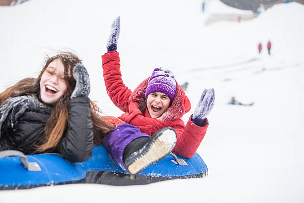 istock Two Kids having fun snow tubing 526260661