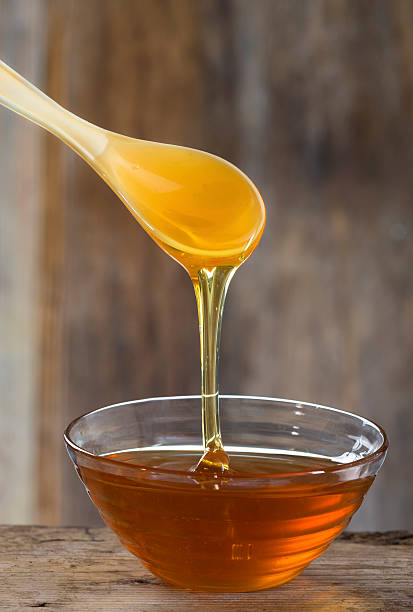 istock Bowl  of honey and a plastic spoon 526260733