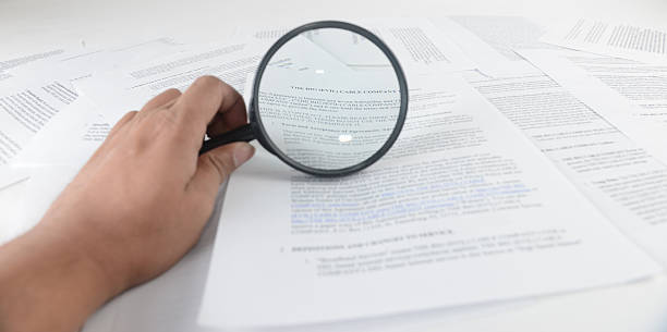 Contract and agreement Reading thoroughly through a contract agreement. Reading the fine print. evil corporation stock pictures, royalty-free photos & images