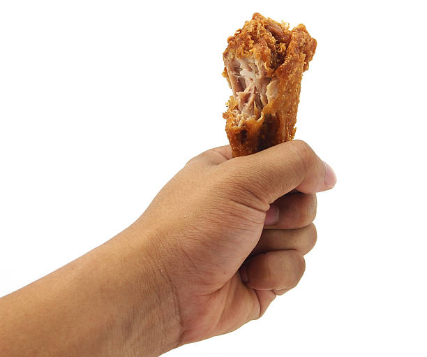 Hand hold fried chicken isolated on white stock photo
