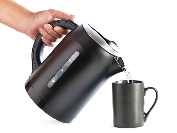 istock Modern kettle pouring water into cup isolated on white 526274975