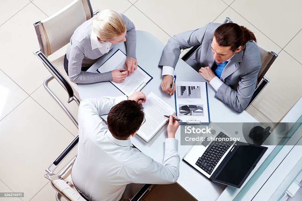 Conversation View from above of business team sitting at table in the office and communicating with each other Adult Stock Photo