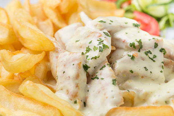 Close up of chicken in mushroom sauce with french fries in plate