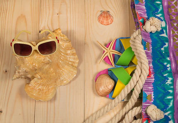 istock beach bag, flip flops, sunglasses,  on wooden background. Top view 526276612