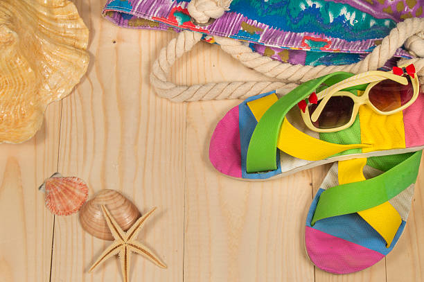 istock beach bag, flip flops, sunglasses,  on wooden background. Top view 526276692