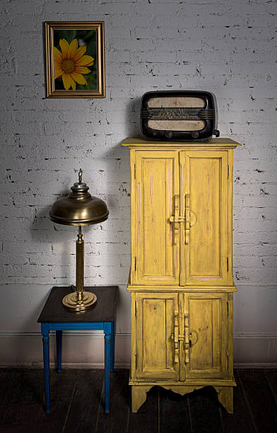 istock Yellow cupboard, old radio, brass table lamp and small table 526279304